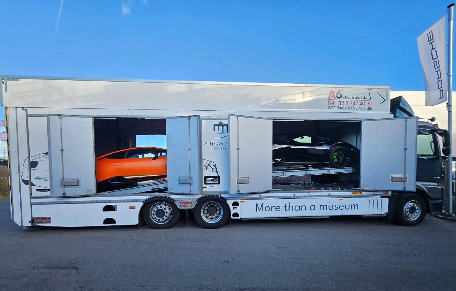 Autotransporter met open flanken geladen met twee Lamborghini's