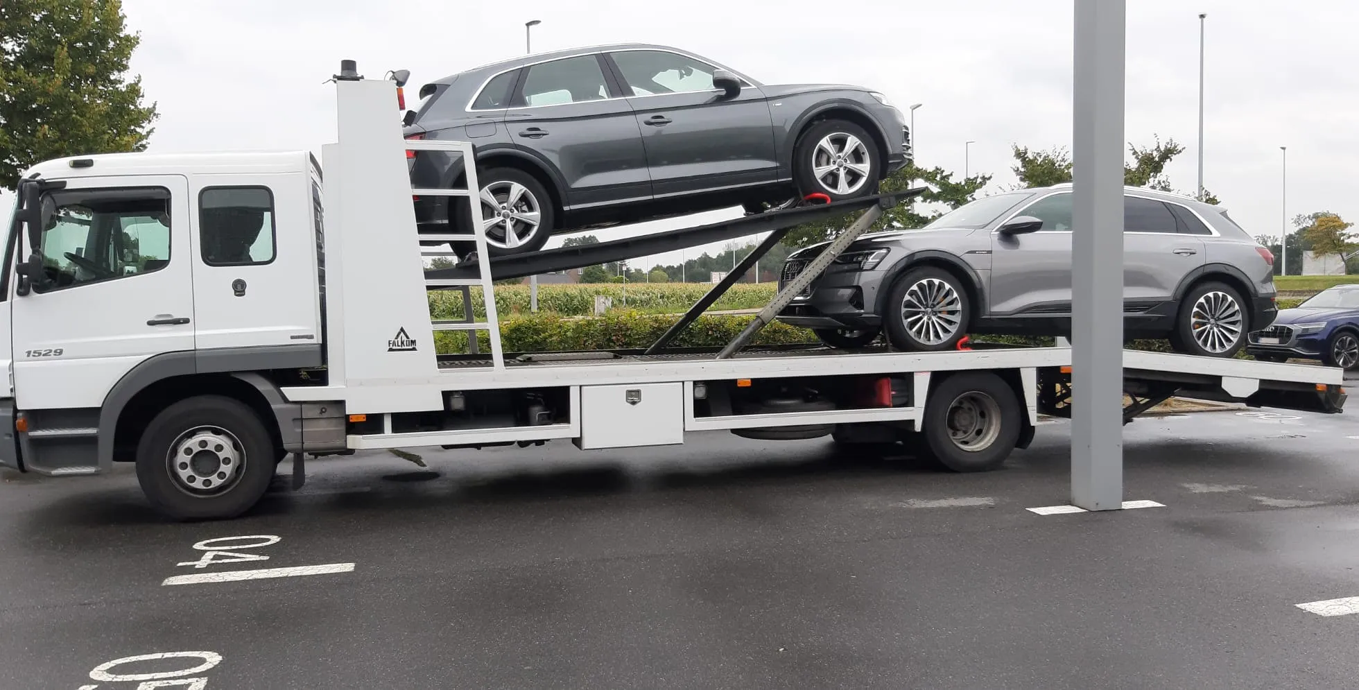 Deux SUV Audi chargés sur les deux ponts d'un camion ouvert